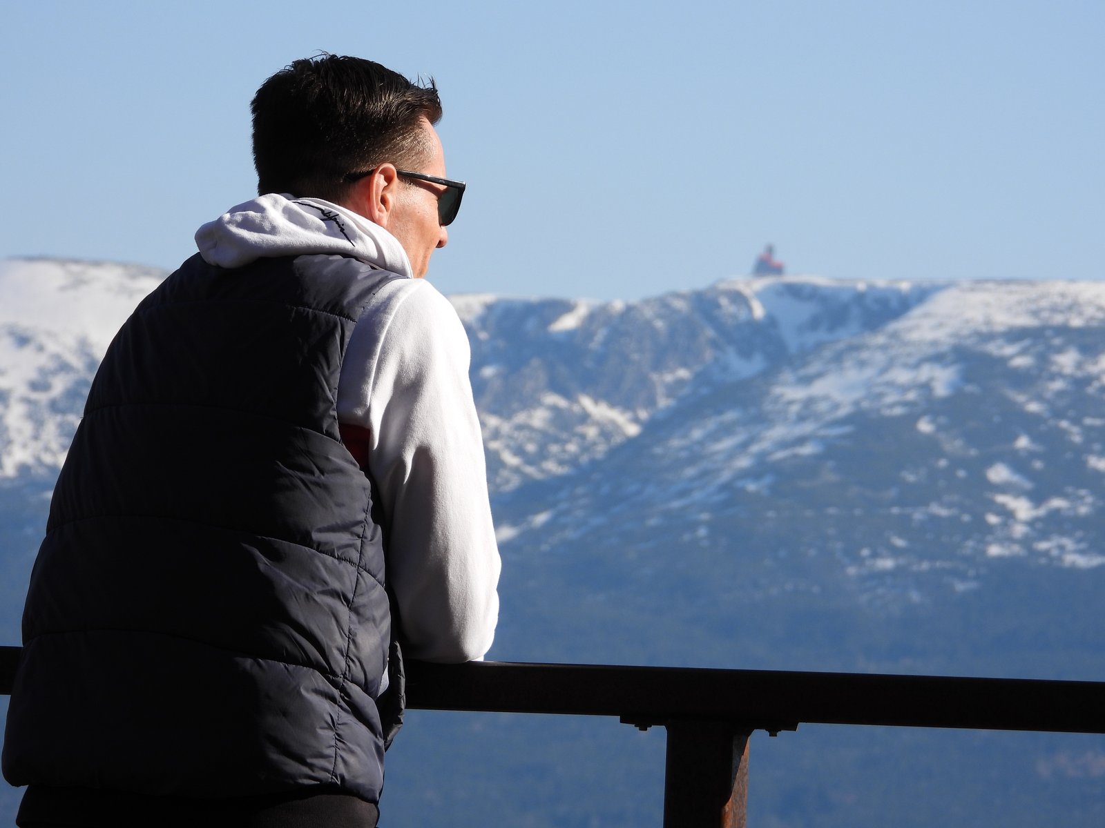 Papa schaut auf verschneite Berge — Familie Zauberwasser im Winter